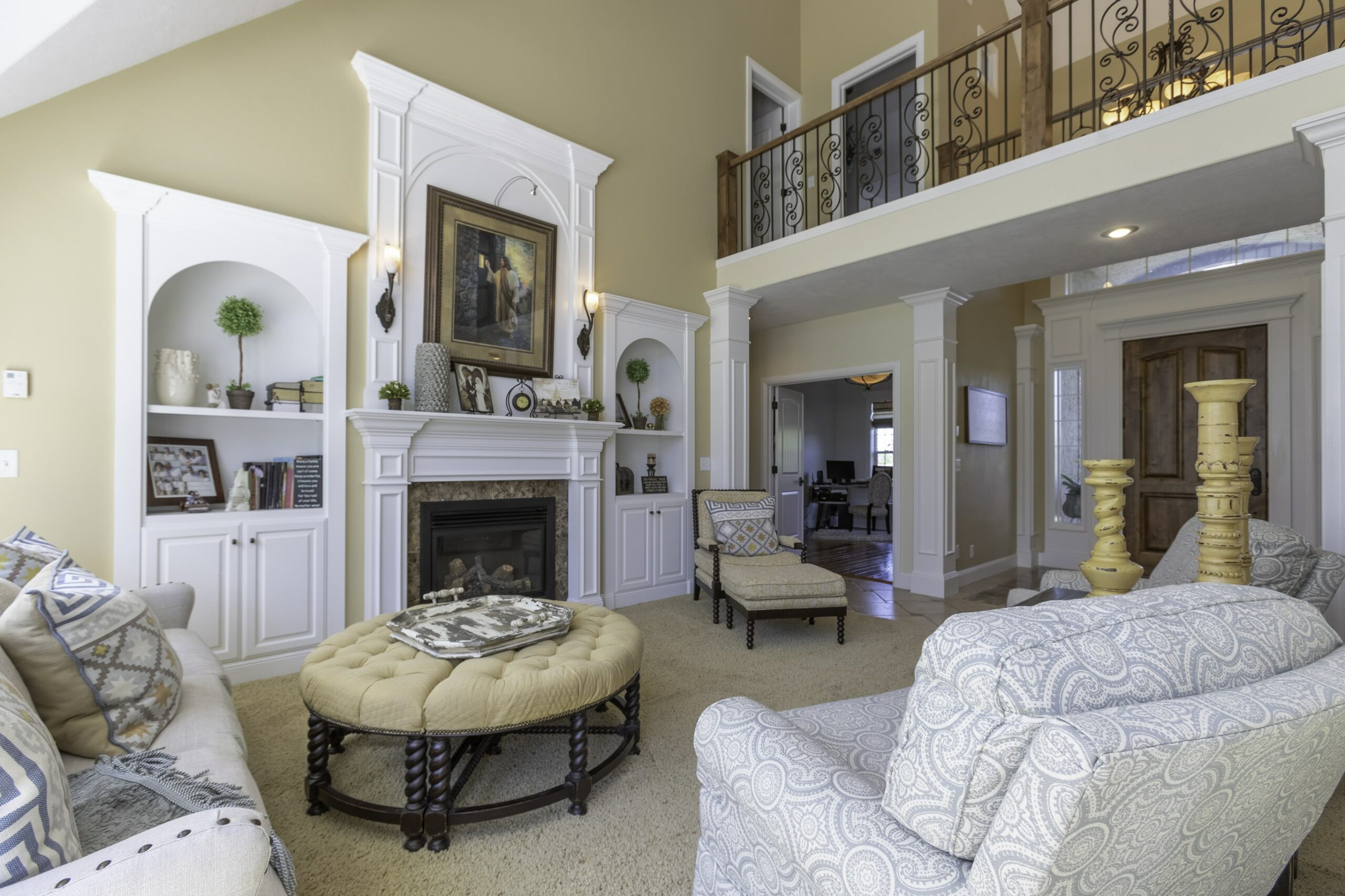 A home living area painted in white and cream green, featuring a sofa set and wall frames